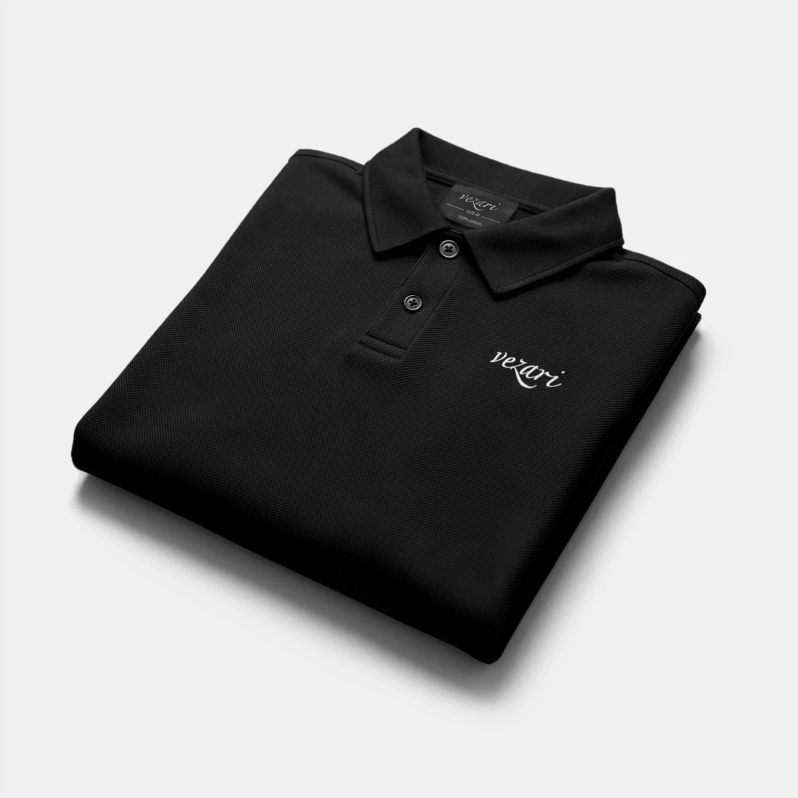 Folded black Casual Fit Polo showing the vezari chest logo
